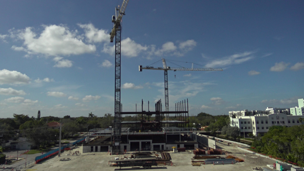 Construction progress of the Fort Lauderdale U.S. Courthouse with a crane lifting materials and multiple floors/levels under construction.